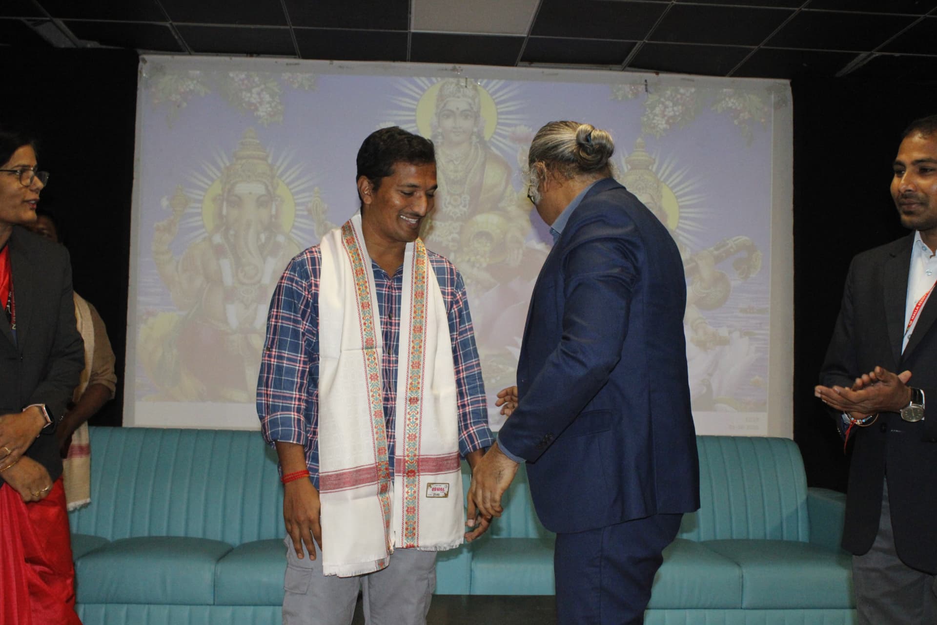 Navaneeth Reddy greeting a college representative on stage